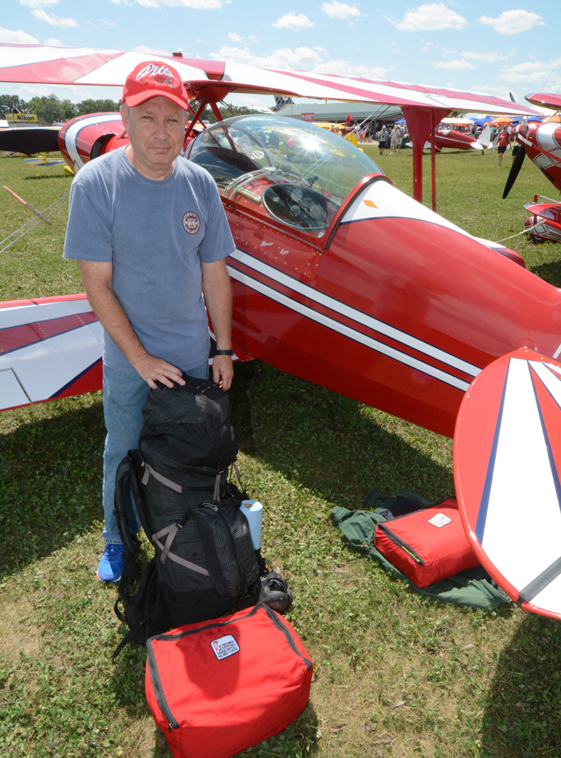 Roger Thompson of Springfield, Illinois models what the well-dressed Pitts pilot wears to Air Venture: one S-2A, a huge backpack and some Softie duffles. Roger had just tied down and was headed for several days tenting it in Camp Scholler when we crossed paths. 